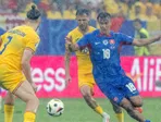 Dávid Strelec, Alexandru Cicaldau a Radu Dragusin  v hustom daždi počas zápasu základnej E-skupiny Slovensko - Rumunsko na ME 2024 vo futbale 