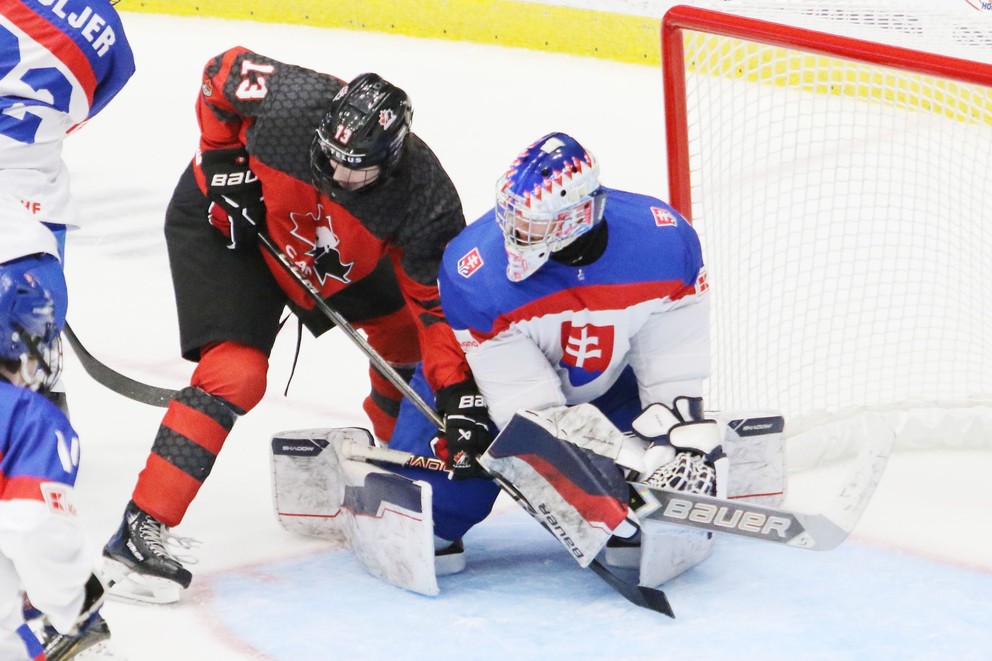 Michal Prádel zasahuje proti Tylerovi Hopkinsovi v zápase Slovensko - Kanada v semifinále MS 18 v hokeji.